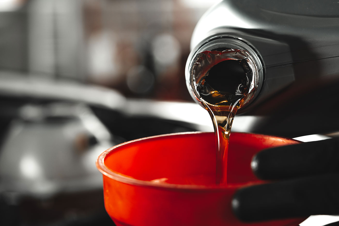 close-up-car-service-worker-pouring-new-oil-into-car-engine